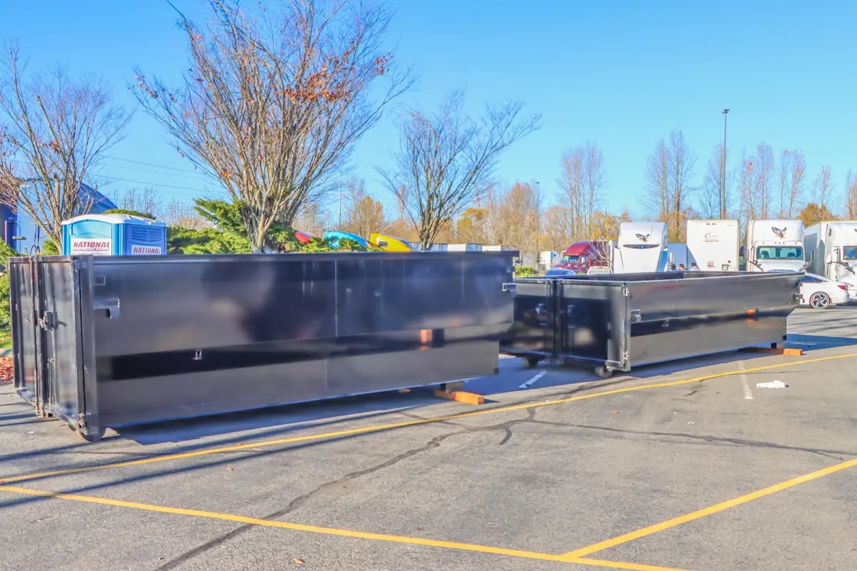 Professional dumpster rental service with roll-off container on residential driveway in Walpole